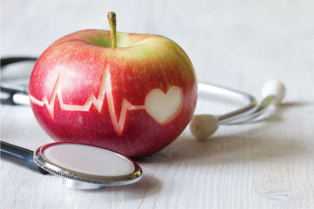 Apple with heart engraving and stethoscope